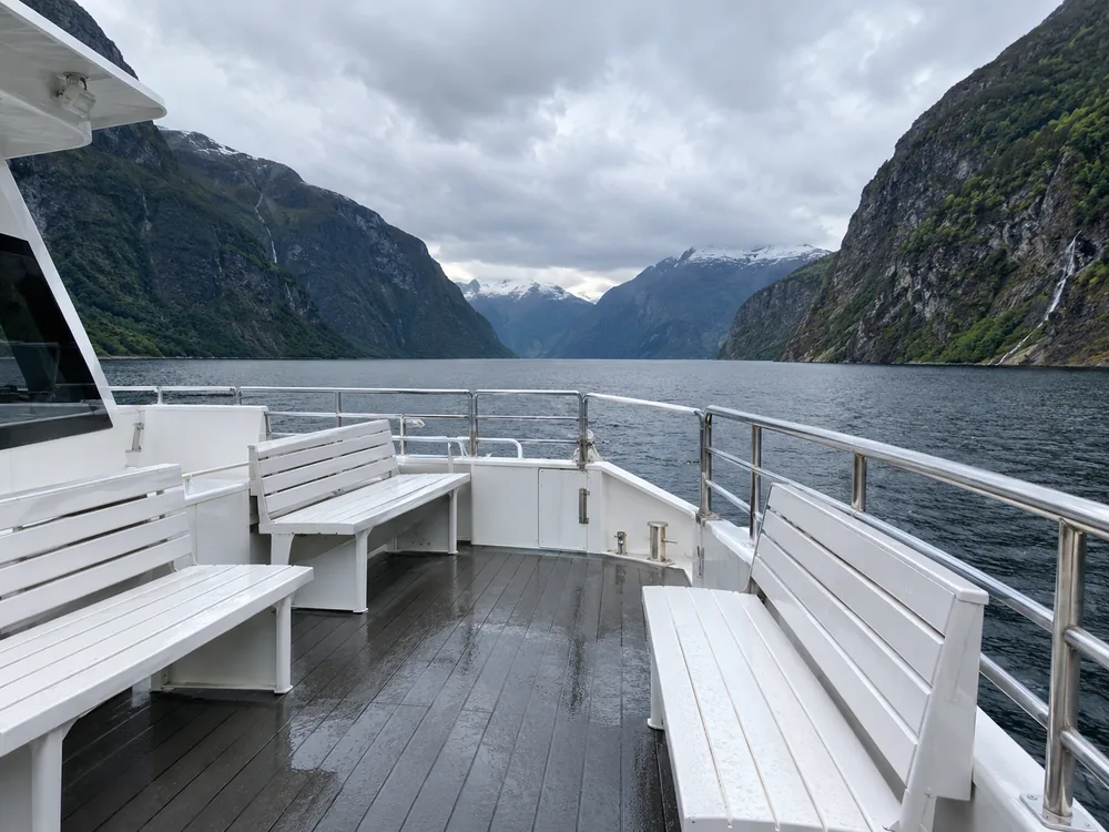 Det åpne utsiktsdekket på en sightseeingkatamaran, der du står når båten går gjennom trange passasjer